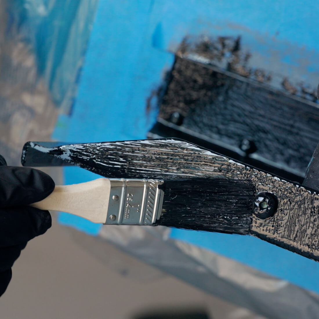 TotalBoat Outdrive AF Prop and Outdrive Antifouling paint being brushed on boat metals close up