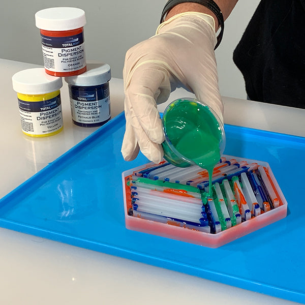 TotalBoat Pigment Dispersion Green, mixed into epoxy, being poured into a mold