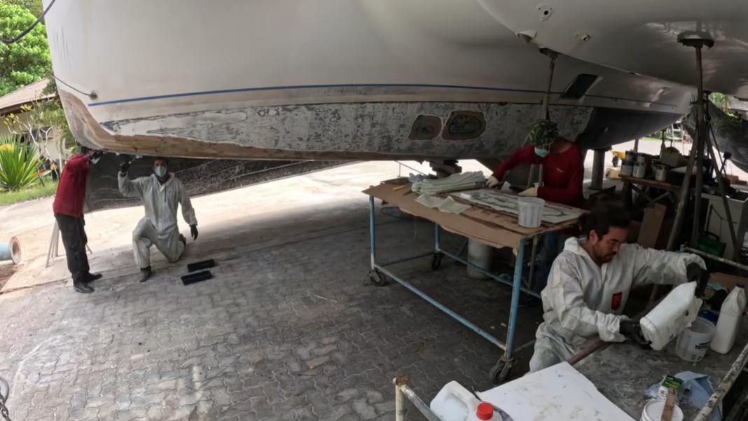 several people working to fiberglass a boat