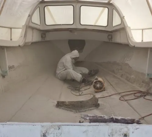 Joel Hanneman sanding the interior of a Steiger 25 during a complete boat restoration