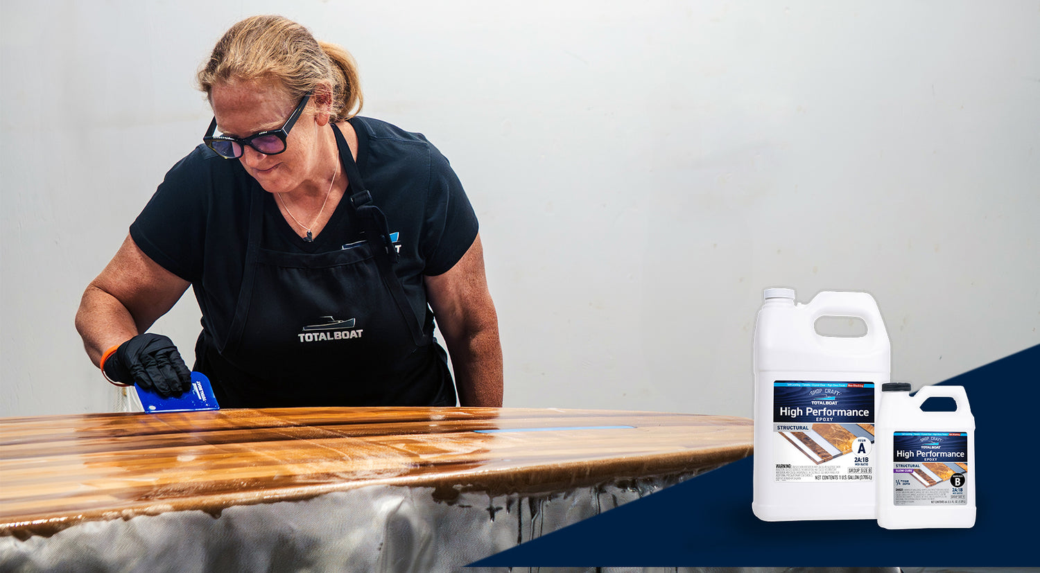 Kristin Brown from TotalBoat spreading High Performance Epoxy Resin on paddle board with packaging displayed