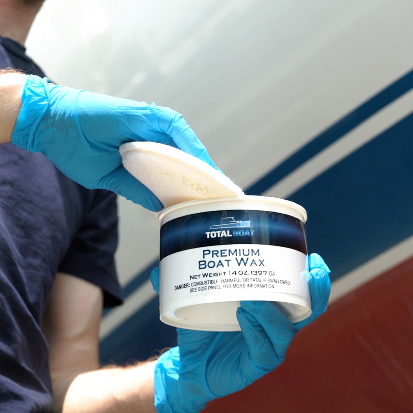 TotalBoat Premium Boat Wax being applied to a boat with a pad