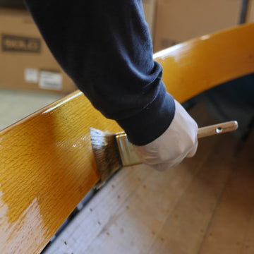 TotalBoat Halcyon Water-Based Marine Varnish applying amber gloss to a boat