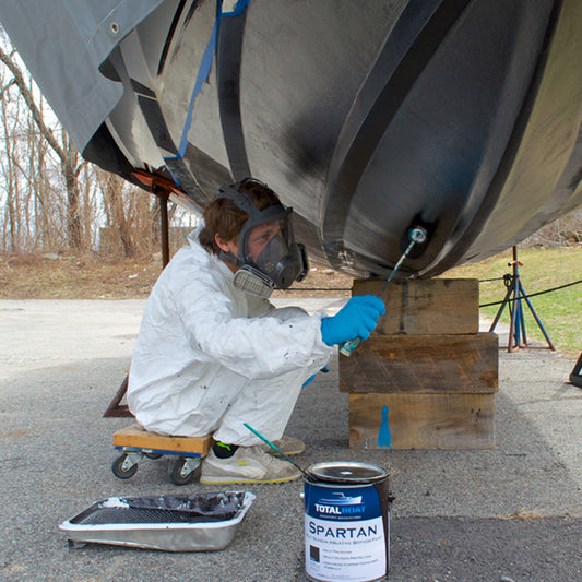 TotalBoat Spartan Multi-Season Antifouling Paint Black being applied with a roller on the bottom of a boat