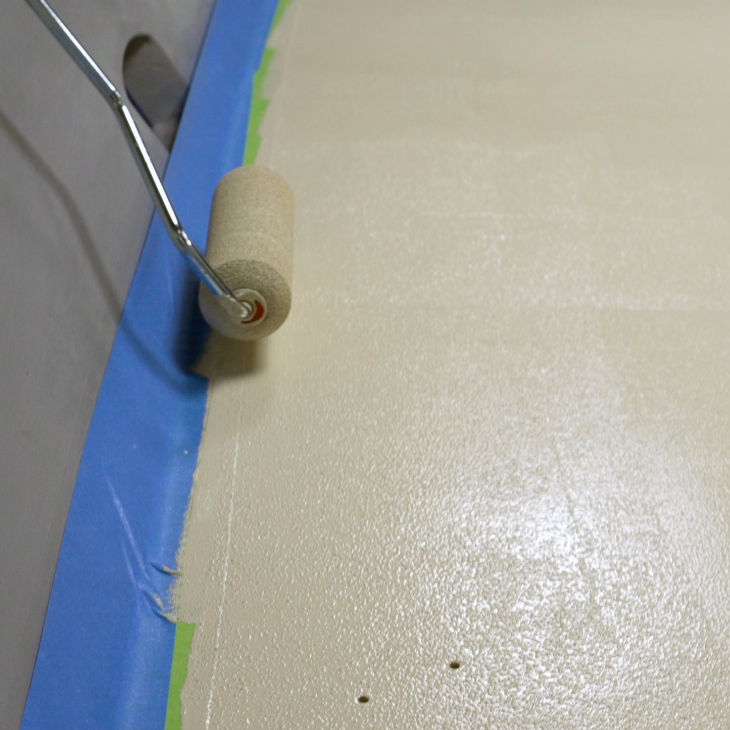 TotalBoat TotalTread Non-Skid Marine Deck Paint sand beige being rolled on a boat