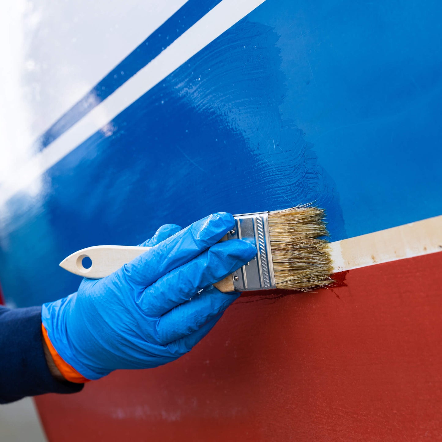 TotalBoat White Knight Fiberglass Stain Remover being brushed on a boat